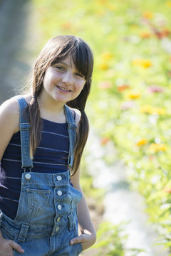 Summer on an organic farm. A young girl in a field of flowers.