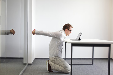 exercise during office work - man with tablet in his office