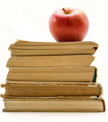 Stack of old books with red apple isolated