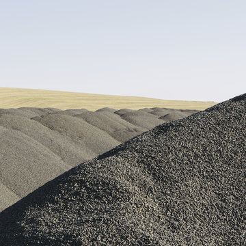 Gravel piles used for road maintenance and construction, a row of heaps near Pullman, Washington, USA.