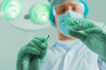 Male surgeon holds a scalpel