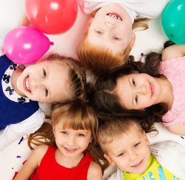 Croup of happy children lying in a circle