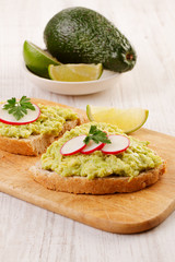 Two sandwiches with avocado and radish