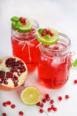 Two glasses with red pomgranate juice, lime and mint.