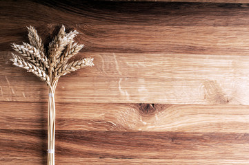 Bundle of wheat on wooden background.