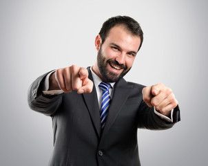 Businessman pointing to the front over grey background