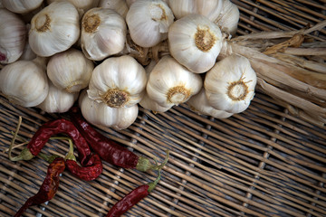 Organic garlic bulbs with red chilly pepper on wooden background