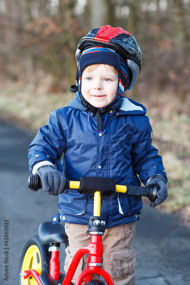 Wall mural 2 years old toddler riding on his first bike