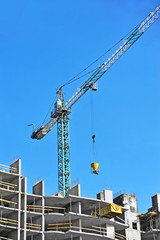 Crane and building construction site against blue sky