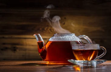 Foto auf Acrylglas Tee Glasteekanne und -becher auf dem hölzernen Hintergrund