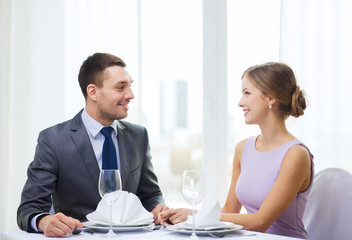 smiling couple looking at each other at restaurant