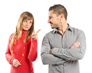 Woman pointing his girlfriend over white background