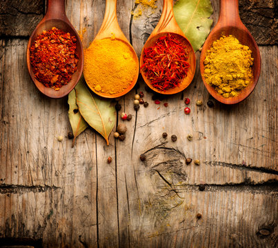 Spices. Curry, saffron, turmeric, cinnamon over wood