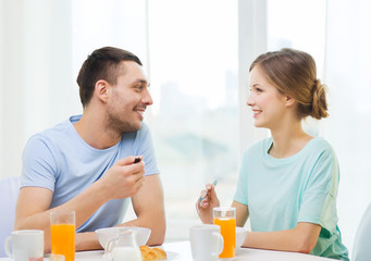 smiling couple having breakfast at home