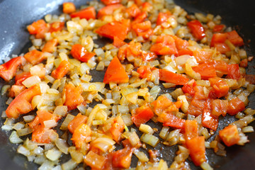 onion and tomato fried in a pan