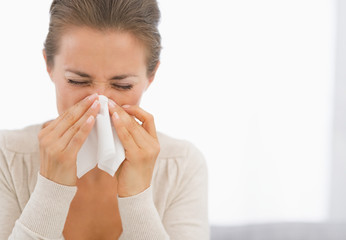 Portrait of young woman blowing nose