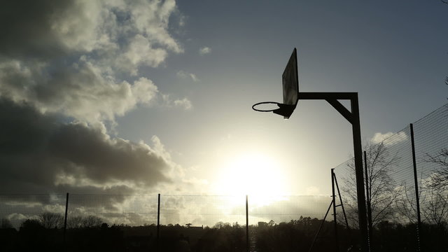 Beautiful time lapse of sun in the clouds on a basketball court