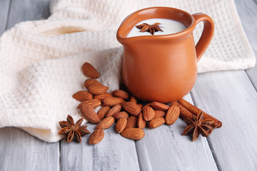 Almond milk in jug with almonds in bowl,