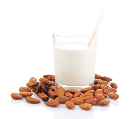 Almond milk in glass with almonds, isolated on white