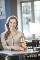 beautiful young woman drinking a wineglass alone in a bar