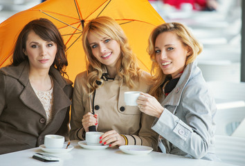 Three women, the coffee and the umbrella