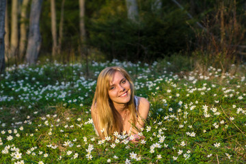 Young pretty blond woman on a meadow with flowers