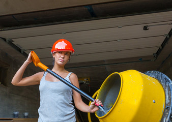 Pretty young woman builder and concrete mixer