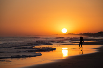 niña jugando en la playa en el atardecer en uruguay