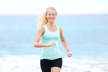 Running woman jogging outside on beach