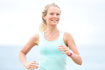 Runner woman running outdoors on beach