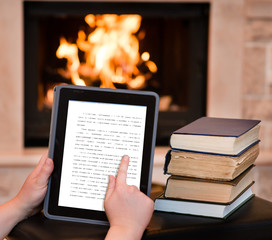 person using digital tablet PC near the fireplace