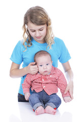 Girl examins the forehead of a baby