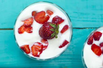 Bowls of strawberry smoothie on vibrant wooden table