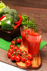 Two glasses of tomato juice and different vegetables