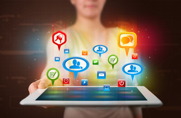 Girl presenting a tablet with colorful social icons and signs