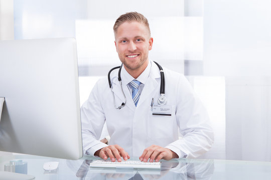 Smiling doctor or consultant sitting at a desk