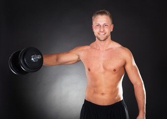 Fototapeta na wymiar Muscular fit young man working out with weights