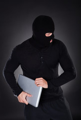 Thief stealing a laptop computer
