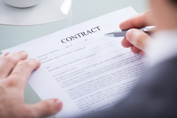 Businessperson Holding Pen On A Document