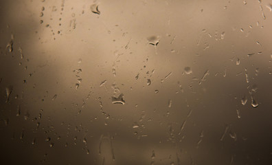 Rain drops on window across clouds