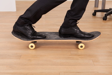 Low section of businessman on skateboard - Powered by Adobe