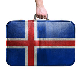 Tourist hand holding vintage leather travel bag with flag of Ice