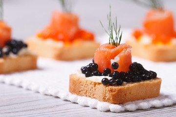 Canapes with black sturgeon caviar, salmon and dill. macro.