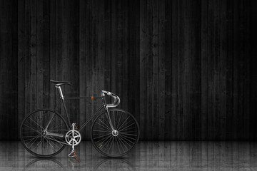 Fototapeta na wymiar Klasyczny rower bieg na stałe czarnym scenie drewna