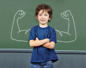 Strong child with muscles in school