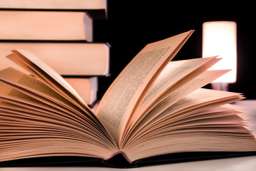 Buch aufgeschlagen vor Bücherstapel