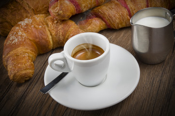 Hot coffee and fresh croissants on the wood table