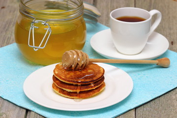Pancakes with honey on white dishware