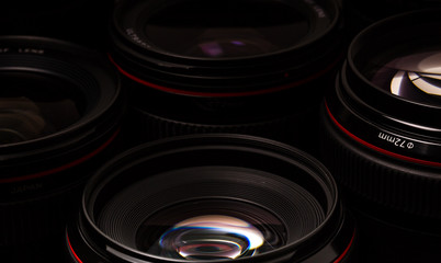 Modern camera lenses with reflections, low key image