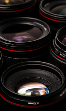 Modern camera lenses with reflections, low key image